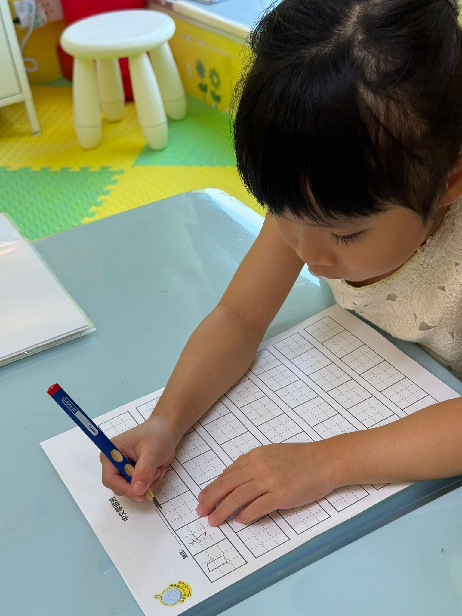 小朋友喺格仔簿寫中文字