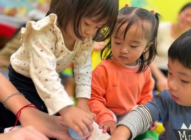 幾個小朋友圍住檯面一齊做活動